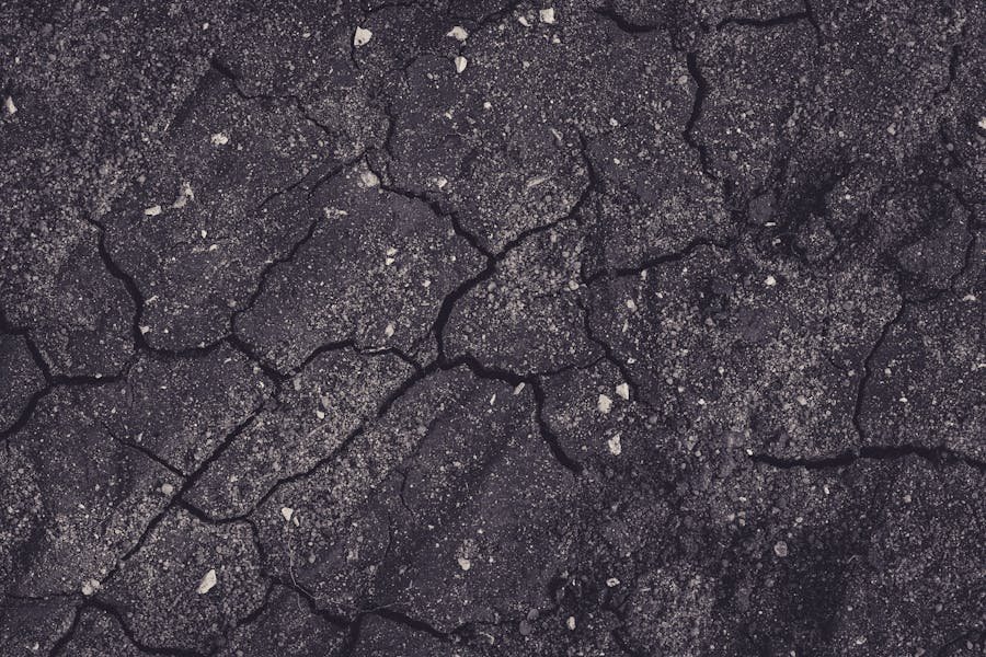 Before photo showing cracked and deteriorating asphalt surface on a commercial parking lot requiring professional crack filling repair