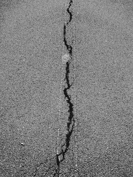 Crack filling in progress on commercial parking lot